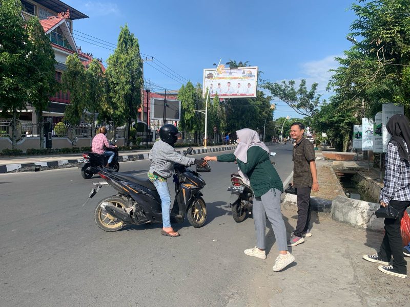 BERBAGI. Suasana pembagian paket makanan kepada pengendara yang melintas di depan Kantor Pegadaian Samarinda Jalan Basuki Rahmat, dalam program Jumat Berkah.